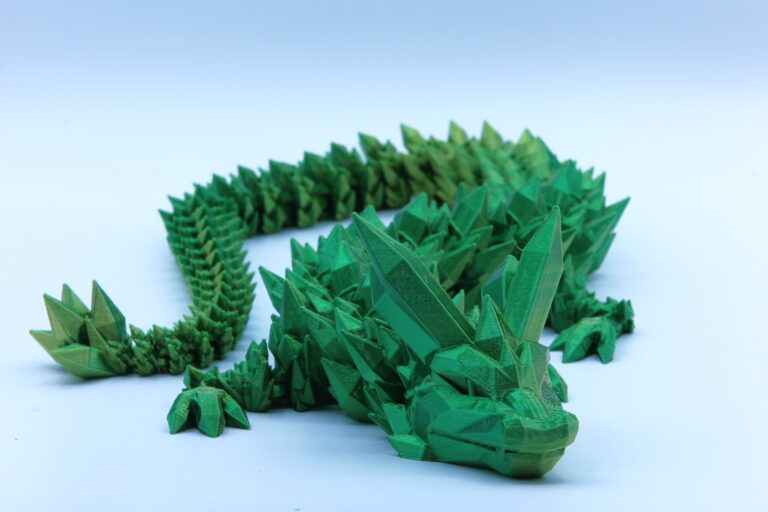 Filmbeli 3D nyomtatott sárkány figura, zöld színben.