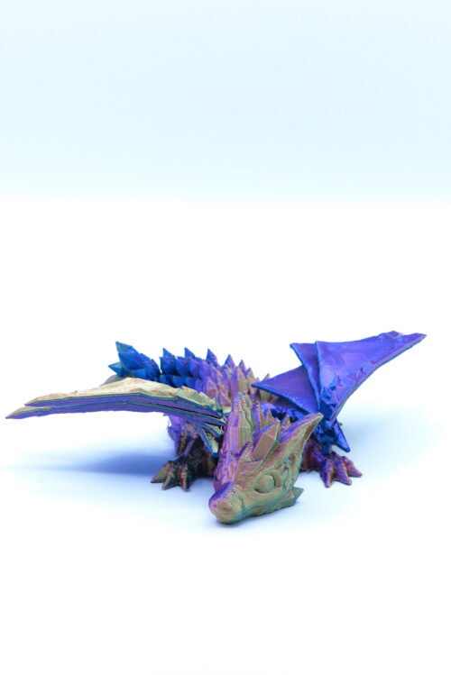 Filmbeli 3D nyomtatott kicsi sárkány figura, lila színben kis szárnyakkal.