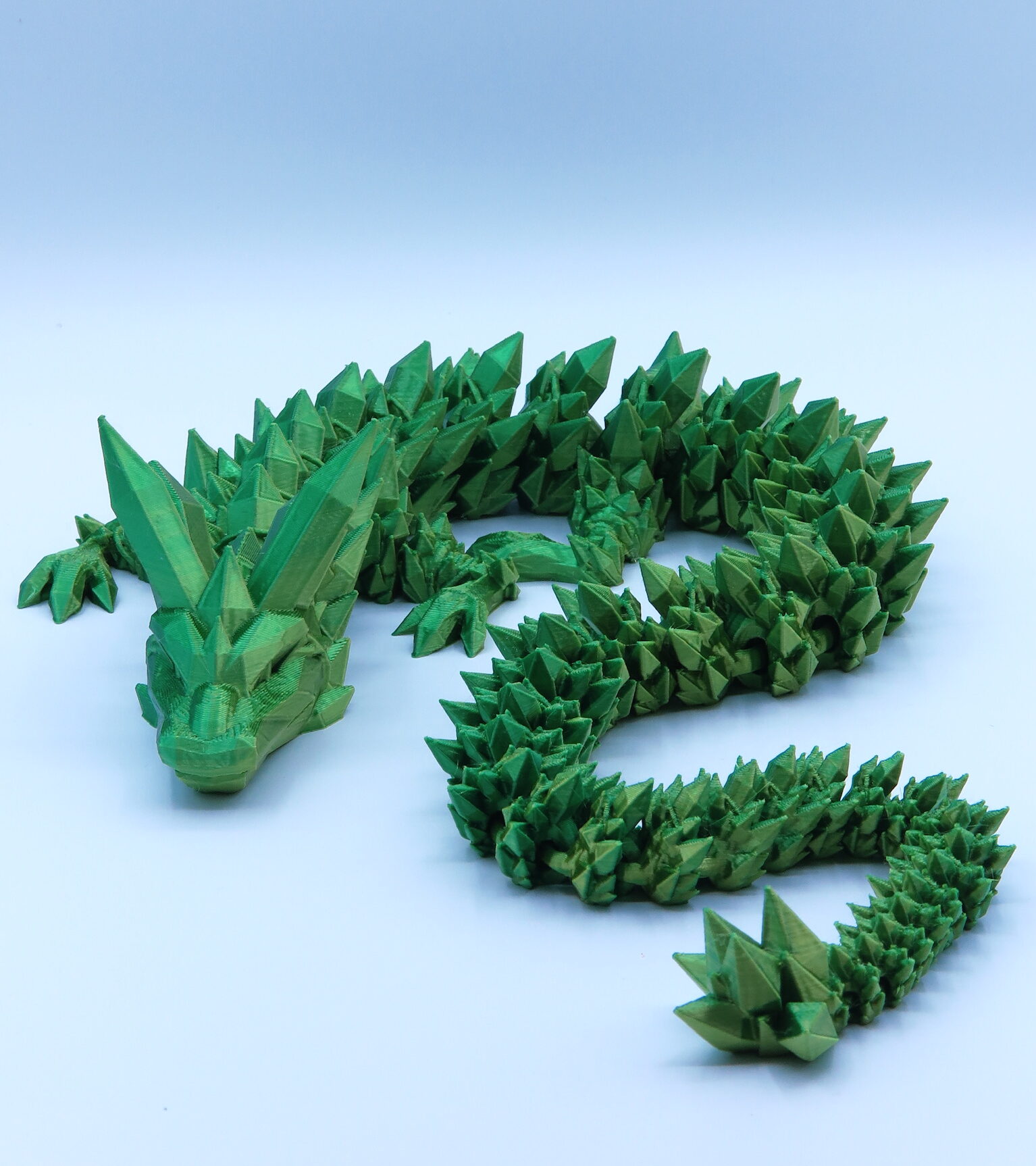 Részletgazdag 3D nyomtatott sárkány figura, zöld színben nagy szárnyakkal.